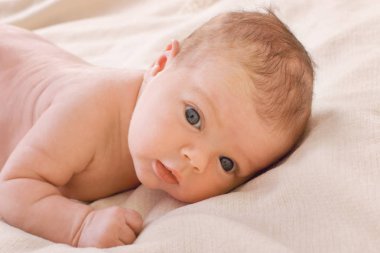 Tatlı küçük bebek sessizce beyaz bir battaniye ile yatakta yatıyordu 