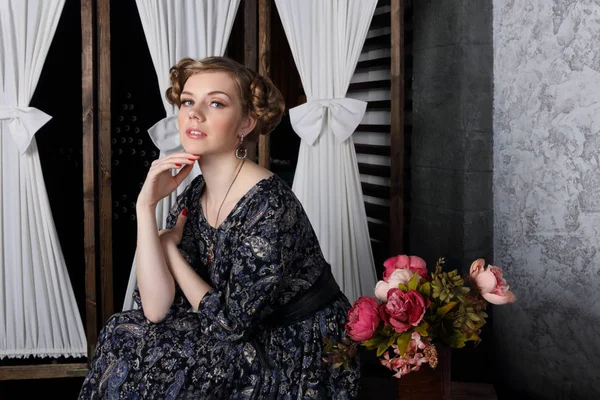 Pretty young woman with hairdo and makeup poses in studio — Stock Photo, Image