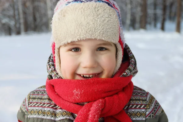 快乐帅气的小男孩，用红色的围巾和帽子微笑 — 图库照片