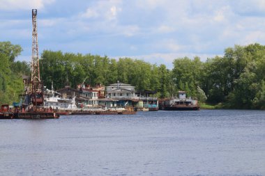 Nehir paslı vinçler ile koyu yeşil t arasında güneşli günde eski iskele