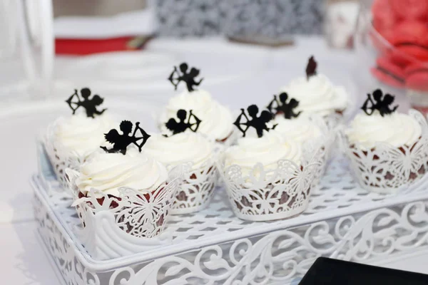 Zoete witte cupcakes met kleine Cupido zijn op tafel tijdens de celeb — Stockfoto