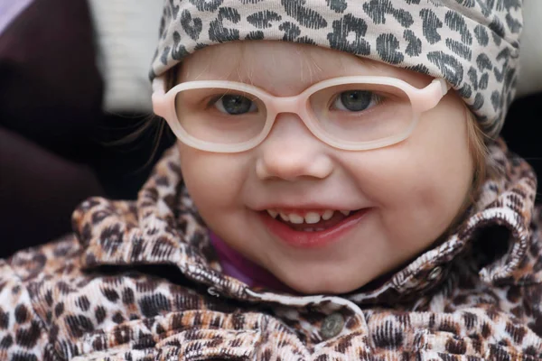 Joyeux petite fille mignonne en faux verres et robe imprimé léopard — Photo