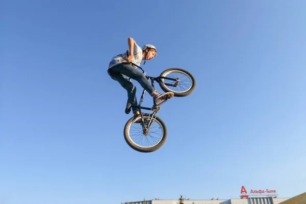 Perm, Rusland - 20 augustus 2016: Jonge man in een witte helm springt op de fiets — Stockfoto