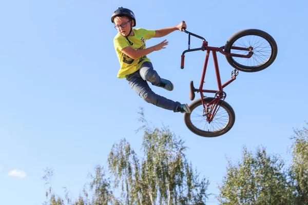 PERM, RUSSIA - 20 agosto 2016: il bambino in giallo in bici in aria — Foto Stock