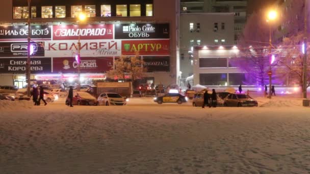Menschen und Autos ziehen durch die Leninstraße, Gebäude mit Illumination am Winterabend — Stockvideo