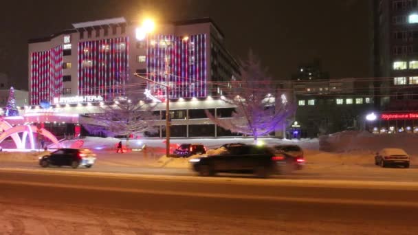 Машины движутся по улице Ленина во время метели в зимний вечер — стоковое видео