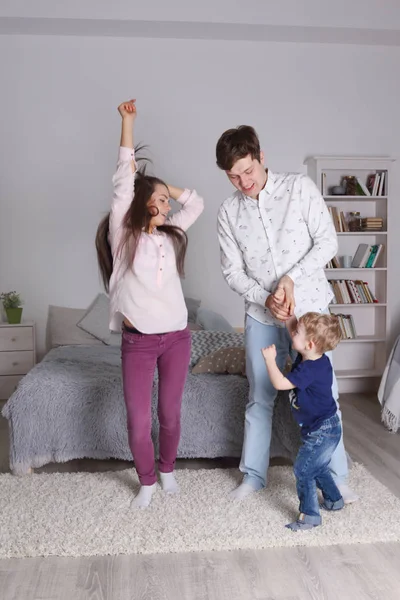 Happy handsome father, mother and little son dance in bedroom at — Stock Photo, Image