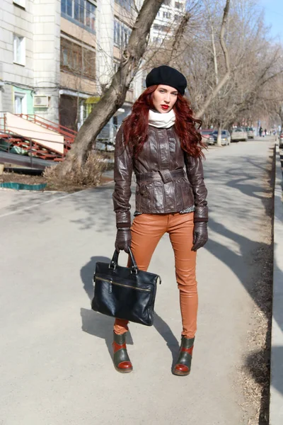 Mladá žena v kožené bundě stojí na ulici na jarní Slunečné d — Stock fotografie