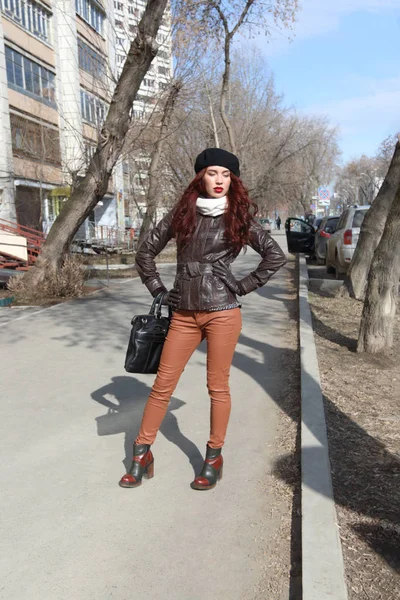 Mladá žena v kožené bundě představuje na ulici na slunečné jaro da — Stock fotografie