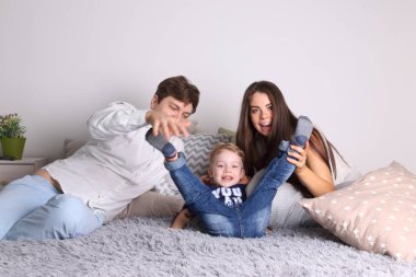 Yakışıklı baba, anne, küçük sevimli oğlu oyun yatakta arasında kullanabilirsin