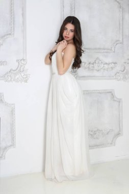 Studio yakınındaki duvara w beyaz uzun elbiseli güzel kadın durumda