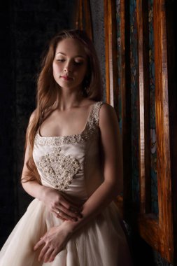 Genç ve güzel kadın siyah stu penceresinde yakınındaki uzun elbise rüyalarda