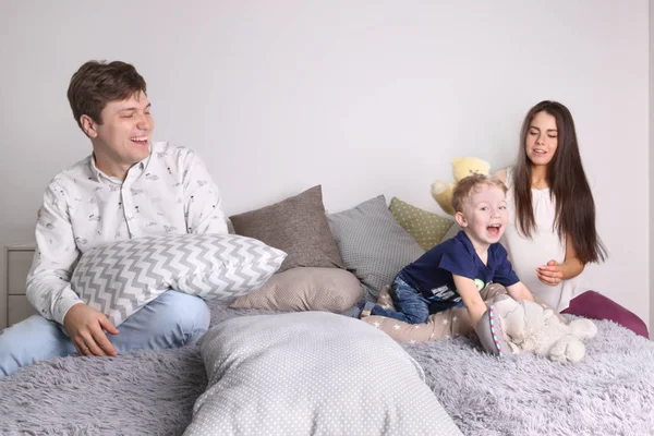 Bello padre, madre, piccolo figlio carino giocare sul letto tra pillo — Foto Stock