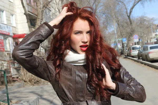 Girl with curly hair in leather jacket poses outdoor at sunny sp — Stock Photo, Image