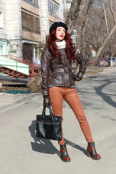 Çanta pozlar güneşli bir bahar günü, sokakta olan genç ve güzel kadın