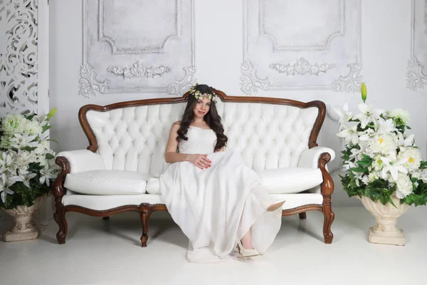 花輪と st のソファで長いドレス ポーズかなりブルネット — ストック写真