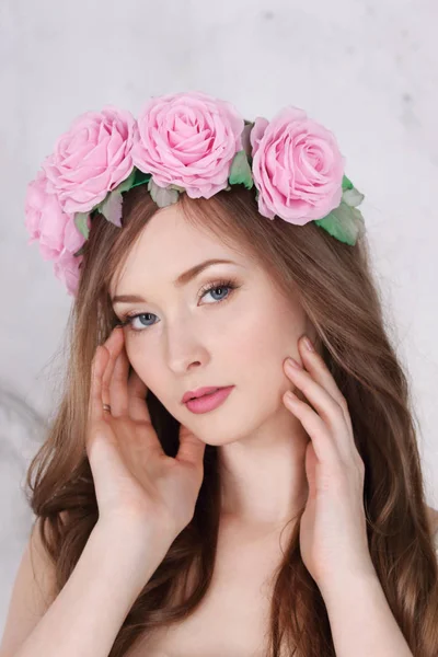 Hermosa mujer en corona de rosas con el pelo largo posa en st blanco —  Fotos de Stock