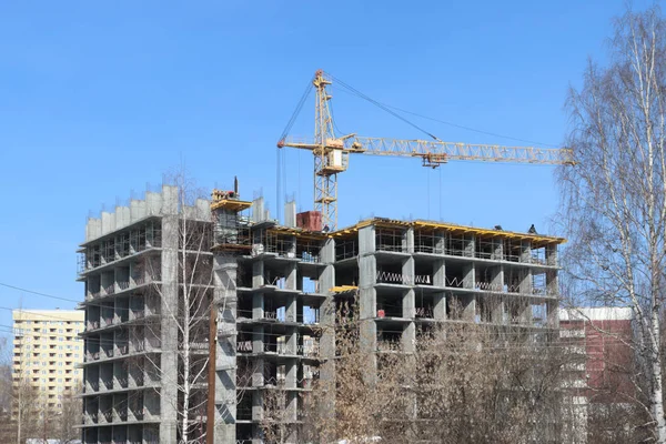 Tamamlanmamış yüksek katlı apartman ve güneşli winte, Vinç