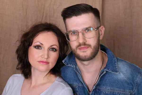 Glad ung kvinna och man i glasögon utgör tillsammans i studion — Stockfoto