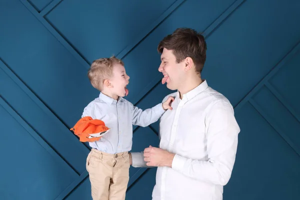 Young father and little son put out tongues for each other in bl — Stock Photo, Image