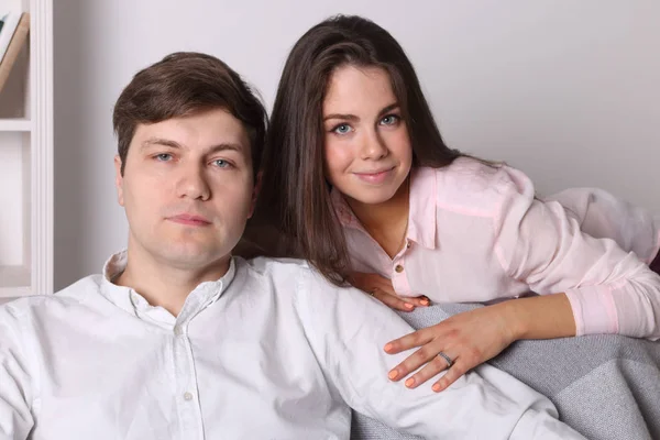 Young woman and man pose together on armchair in living room — Stock Photo, Image