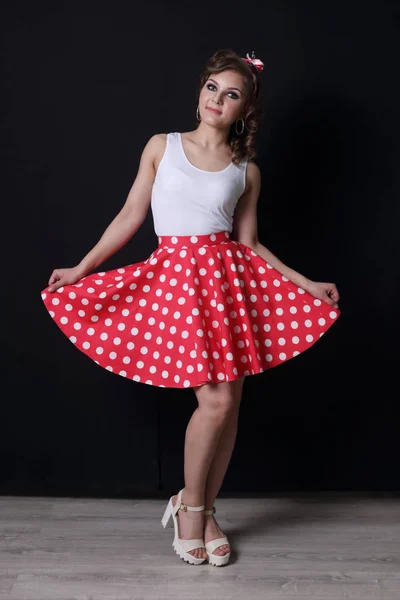 Pinup beautiful girl in red skirt and with curly hair poses in b — Stock Photo, Image