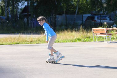 Mutlu kız mavi paten Yaz Bahçesi üzerinde 