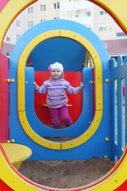 Şapkalı küçük güzel kız yaz çocuk oyun alanı üzerinde çalış