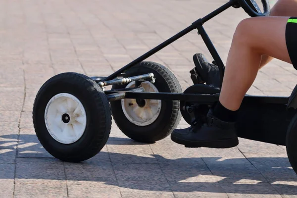 Beine eines Mannes, der an sonnigen Tagen auf einem zu Fuß bedienenden Vierrad unterwegs ist — Stockfoto