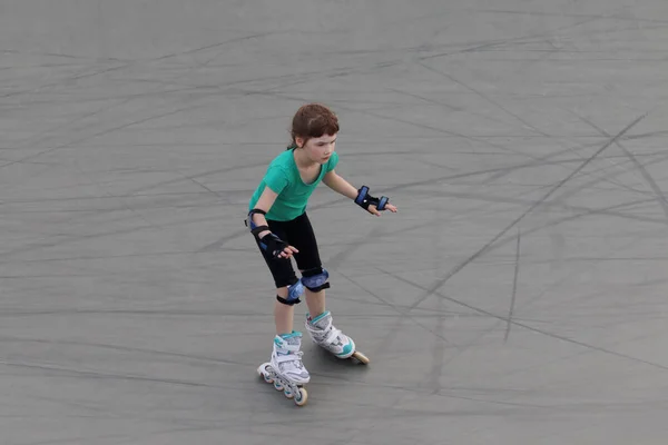 Menina criança patins no playground esporte com rampas — Fotografia de Stock