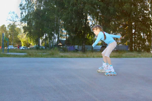 Menina bonita patins no parque infantil no dia ensolarado de verão em t — Fotografia de Stock