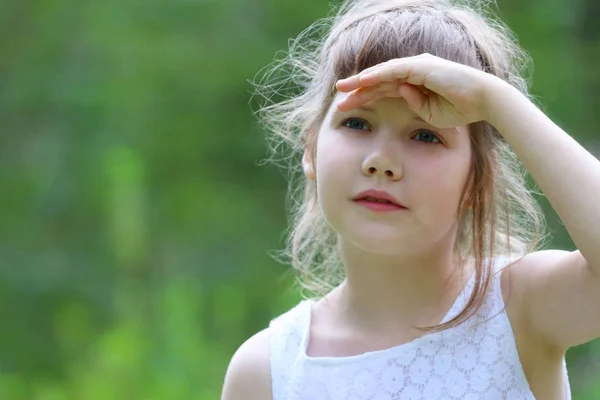 Girl in white looks away at summer sunny day in park, close up, — Stock Photo, Image