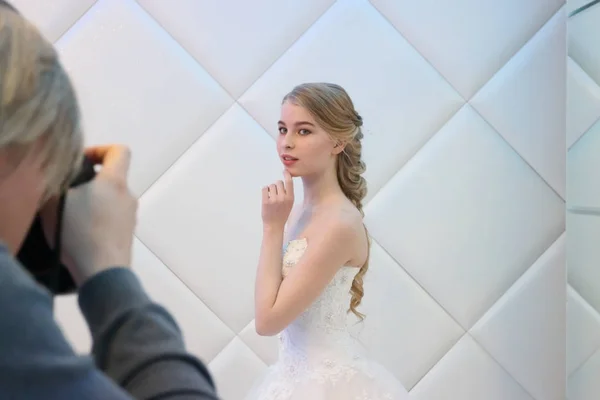 Photographer shoots blonde bride — Stock Photo, Image