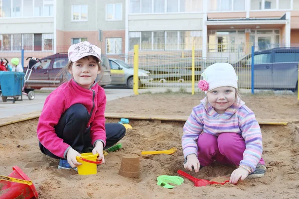 Dos niñas juega en sandbox en el parque infantil en el día de verano — Foto de Stock