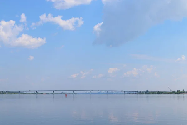 View of river and shore with bridge in distance on sunny summer — Stock Photo, Image