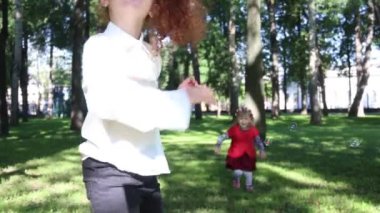 İki güzel kızlar sabun köpüğü yeşil yaz Park yakalamak