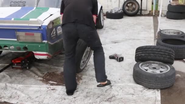 Perm, Rusland - Jul 22, 2017: Man vervangen wiel op de auto bij Open Ural Championship Drift 2017 te drijven — Stockvideo