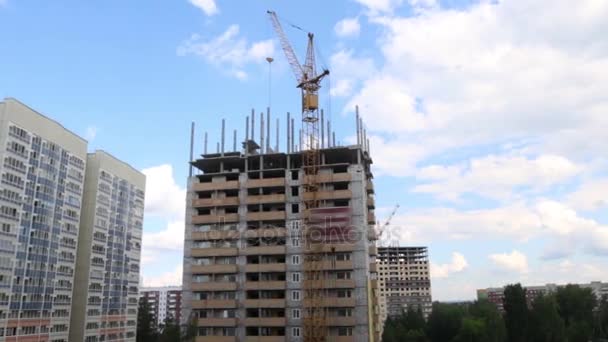 Kraan op de bouwplaats met woongebouw op zomerdag — Stockvideo