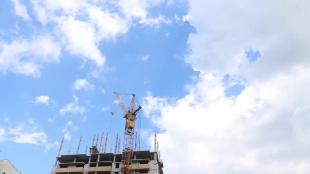 Grúa en el sitio de construcción con edificio residencial alto en verano — Vídeo de stock