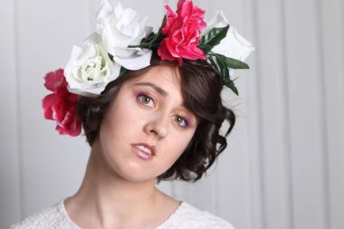 genç esmer kızla temiz cilt, kalıcı makyaj ve çiçek çelenk 