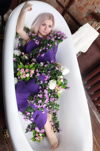 薄紫色のドレスで美しい少女は、花と一緒にお風呂 — ストック写真