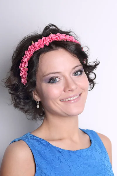 Lächelnde junge brünette Frau mit Kranz auf dem Kopf, Make-up und — Stockfoto