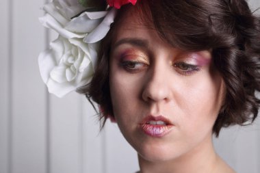 genç esmer kızla temiz cilt, kalıcı makyaj ve çiçek çelenk 