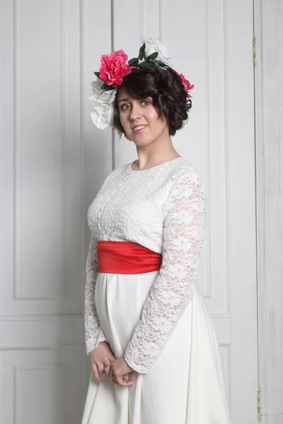 Красивая брюнетка в белом платье с цветочным венком — стоковое фото