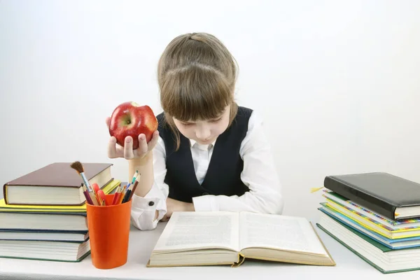 穿校服的女生看书, 在餐桌上吃红苹果 — 图库照片