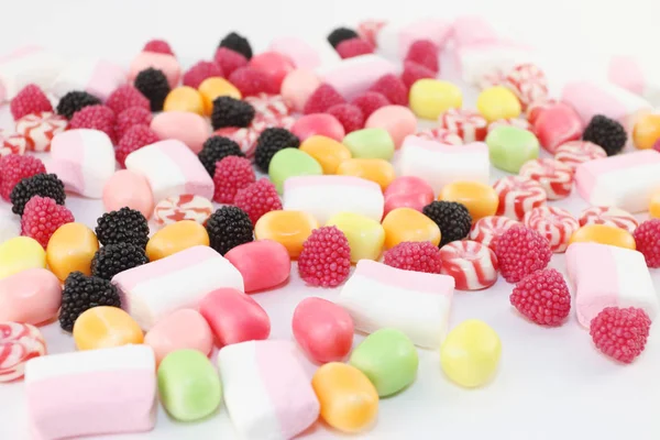 Veel zoete snoepjes en marshmallows op witte ondergrond, close-up — Stockfoto