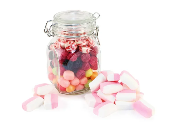 Vaso di vetro con caramelle e marshmallow isolato su dorso bianco — Foto Stock