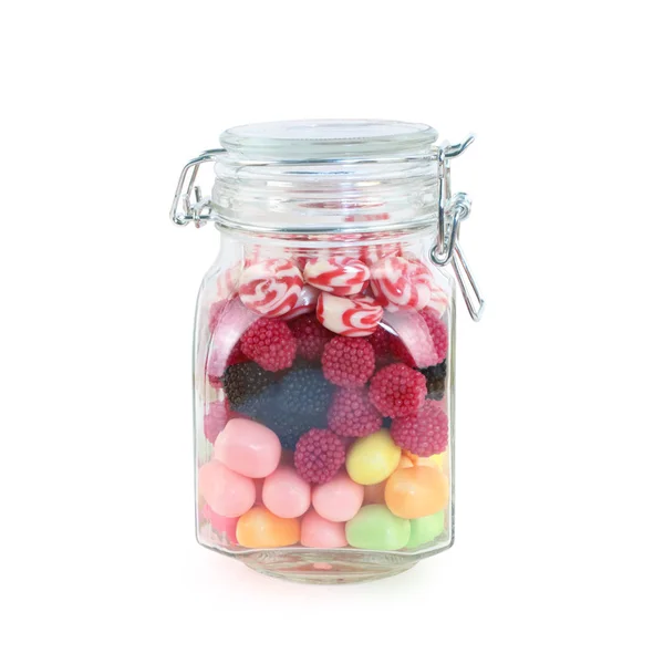 Vaso di vetro con molte caramelle dolci luminose isolate su dorso bianco — Foto Stock
