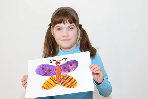 Menina mostra imagem com borboleta após a pintura aquarela em w — Fotografia de Stock