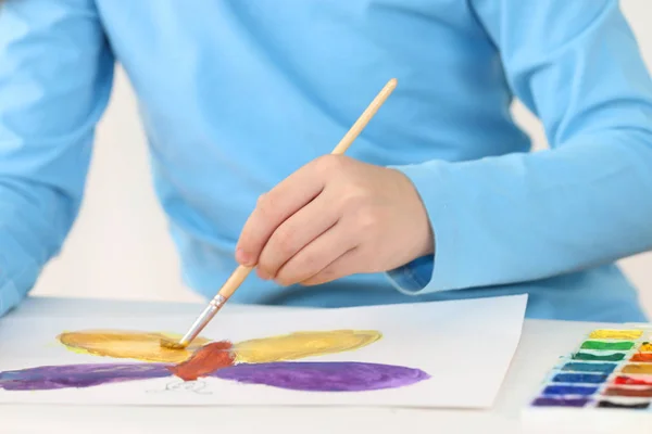 Hands of girl watercolor painting butterfly on table in white ro — Stock Photo, Image